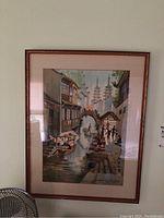 Full view of the framed Asian art print showing the entire scene with canal, boats, bridge, buildings, people, and pagoda towers in the background.