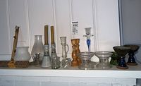 Overview of assorted candle holders and incense sticks arranged on a shelf.