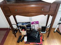 Front view of the wooden hall table showing single drawer with two round knobs and curved apron below.