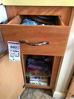 Lower cupboard shelf with multiple boxes of storage bags such as Ziploc, freezer bags, and parchment paper.