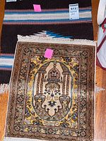 Wool textile with detailed decorative medallion and floral patterns laid flat for display.