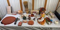 Full collection of assorted fall-themed decorations arranged on a table including pumpkins, wreath, placemats, and signs.