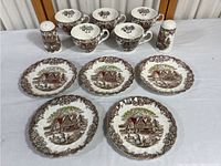 Overview of the five plates and pair of salt and pepper shakers arranged on table displaying design and quantity