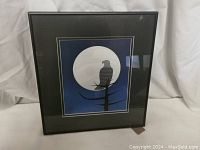 Front view of the framed print showing the full artwork, eagle silhouette against the moon, tree branch, dark frame, and matte border.