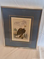 Framed print shown in entirety including silver frame and double matting with blue and gold accents.