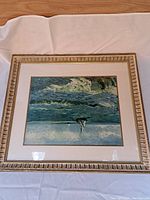Full view of gilt-framed print showing ocean waves and boats.