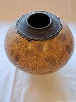 Full view of the round-bodied ceramic vase showing crackle glaze and brown floral patterns.