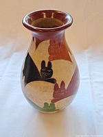 Front angle of the ceramic vase showing colorful cat illustrations and glossy reddish-brown rim.