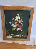 Front view of oil on canvas floral still life painting in oak frame