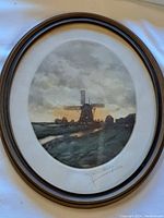 Full view of the ovular framed colour lithograph showing a windmill landscape at sunset/sunrise with a cloudy sky.