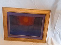 Front view of the framed watercolor showing sunset artwork with orange sun and dark landscape, signed by RH Grooms.