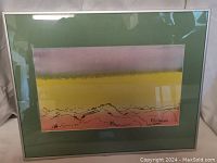 Framed watercolor painting showing the desert sunset scene and signature.