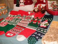 Photo of 8 Christmas stockings laid out including knitted, felt, and polyester types with holiday designs