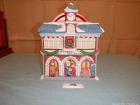 Front view of ceramic Victoria Station cookie jar, detailed with Christmas wreaths and figurines in the entry arches.