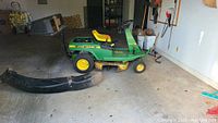 Side view of the John Deere RX75 mower showing deck, tires and seat