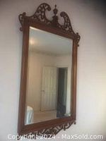 Full view of large rectangular wall mirror with wooden ornate frame in used condition, showing the reflective glass and carved wood details.