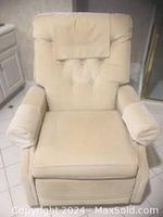 Front view of vintage pale yellow corduroy recliner showing tufted backrest, cushioned armrests with covers, and seat cushion.