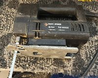 Image showing the full body of the Black and Decker jigsaw labeled as single speed, with attached blade and power cord on a carpeted surface.