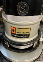 Close-up photo focused on the Black & Decker logo and commercial duty label on the router body.