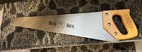 Full view of Buck Bros hand saw showing the wooden handle and steel blade with the brand stamped.