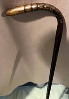 Close-up image of the curved handle and carved groove details of the wooden cane.