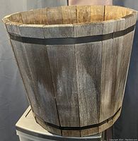 Photo of large wooden planter showing vertical slats and metal bands