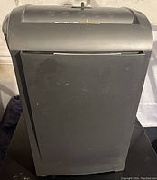 Black paper shredder with control panel and paper entry slot visible.