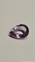 Pear-shaped purple amethyst gemstone showing its faceting and color