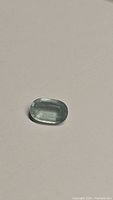 Clear image of natural oval cut aquamarine gemstone showing sky blue color and oval faceted shape.