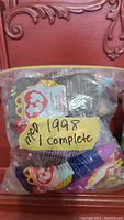 Plastic bag containing 12 unopened 1998 McDonald's Teenie Beanie Babies with Ty tags and a yellow label reading '1998 1 complete'.