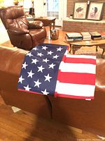 Photo showing American flag draped over sofa in living room