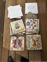 Top view of the full lot assortment of decorated and plain tiles laid out showing various bird and flower patterns and white tiles.