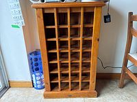 Front view of pine wood wine rack showing multiple grid slots for wine storage