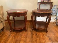 Front view of the two matching wooden end tables next to a beige sofa, showing their size and condition.