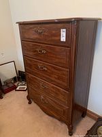 Front view of dresser showing full unit with five carved drawers and brass-tone hardware