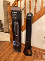 NOMA oscillating tower fan beside its original box, both standing about 42 inches tall.