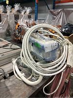 Profile view of blue Graco texture sprayer with coiled hoses and metal base, showing overall condition