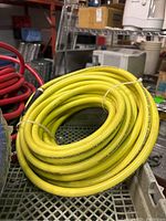 Photo of yellow coiled air hose with printed safety and usage information, showing new or unused condition.