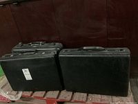 Three worn vintage briefcases shown together, two Samsonite and one Zero Halliburton.