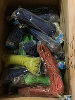 Box filled with many individually packaged colored cords in plastic wrap, showing various colors including yellow, green, blue, orange.