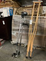 Metal and wooden crutches leaning against pallet wrapped in plastic