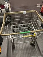 Front angle view of the metal wire basket cart showing the beige top rim and caster wheels.