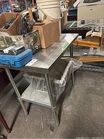 Photo showing the full metal restaurant cart holding boxes and various items, metal frame with lower shelf, worn appearance