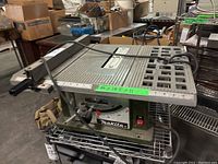Side view of entire table saw on metal shelving showing overall condition and attached power cord