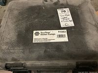 Closed view of black plastic case labeled 'NAPA Tru-Flow Water Pumps 91002' with sellers tag indicating 'Tru-Flow Water Pump Flush tool'