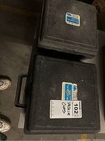 Two black plastic carrying cases labeled Vacuum Cup viewed from above