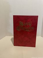 Red hardcover with gold embossed 'Merry Christmas' text on front cover