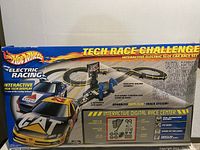Front panel of box displaying Hot Wheels Electric Racing Tech Race Challenge artwork and features