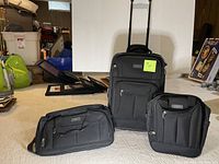 Full view of the three-piece Eddie Bauer luggage set: upright suitcase, knapsack, and shaving case in black.