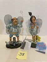 Front view image showing both Wilbur and Maybelle fairy figurines with star wands and accompanying tags on display.